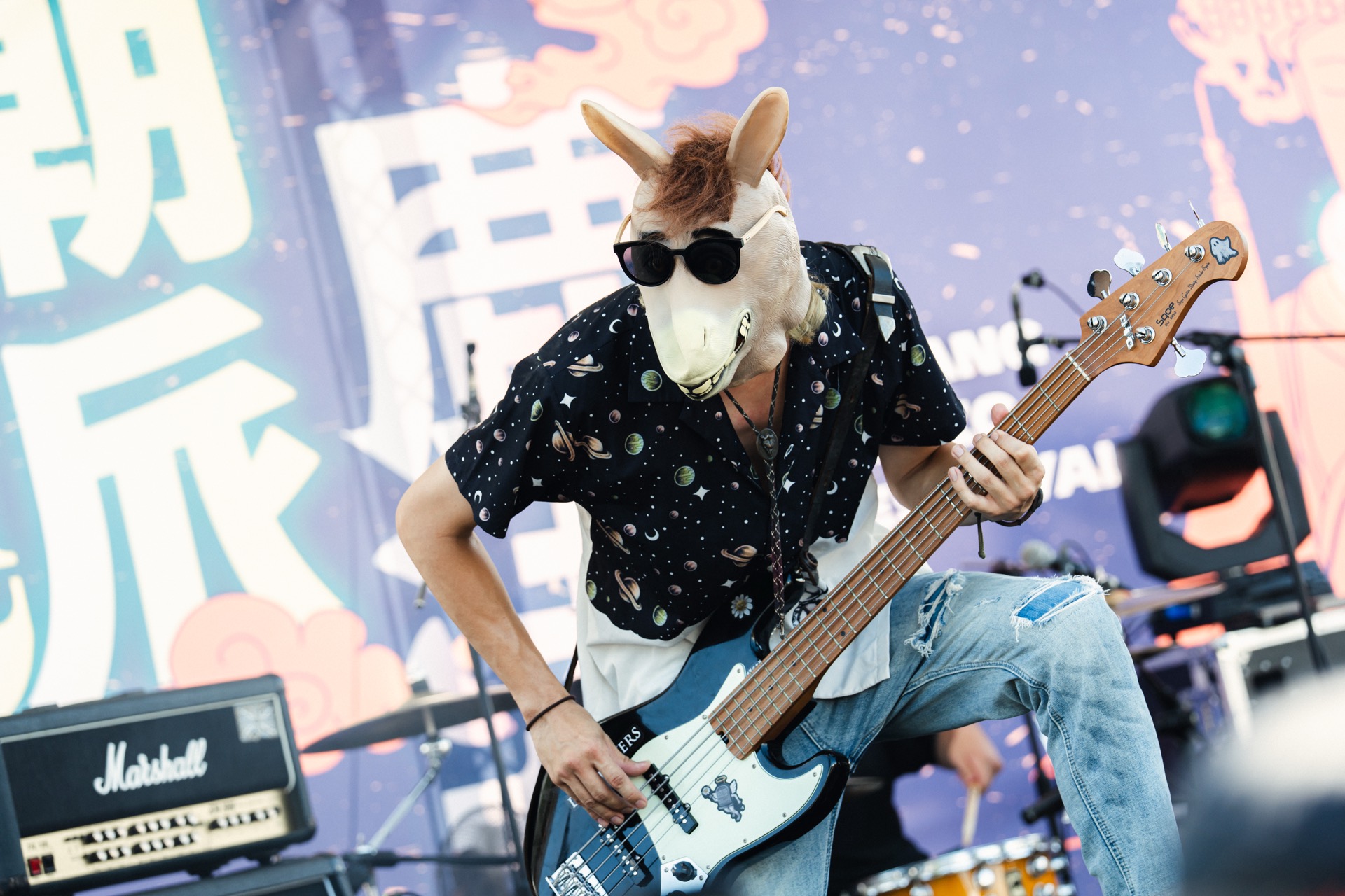 Sasha Wu performing bass in a playful stage outfit